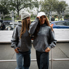 Female model wearing a blue acid wash hoodie, shown from the front at race event
