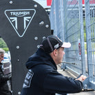 Side-profile image of Fenton Seabright in a black and pink trucker cap during race day preparations