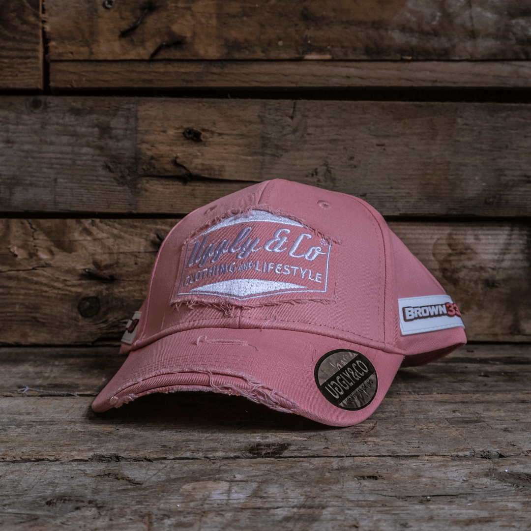 Pink cap with branding on a wooden background
