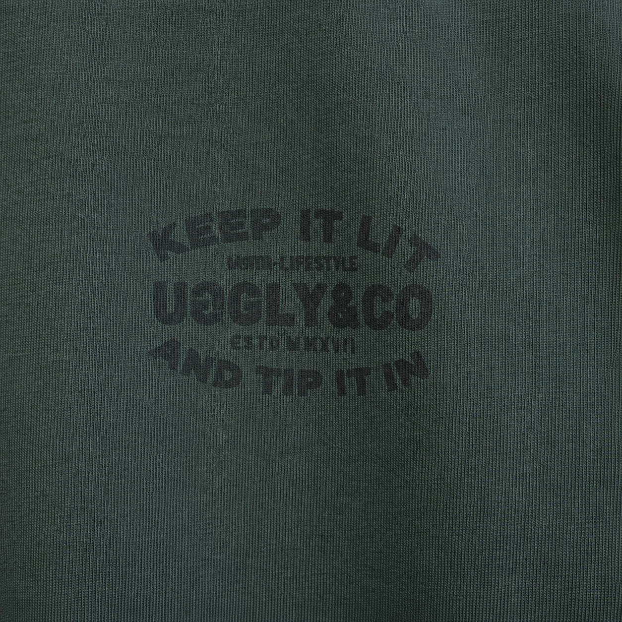 close up product photo of the uggly and co green keep it lit t shirt