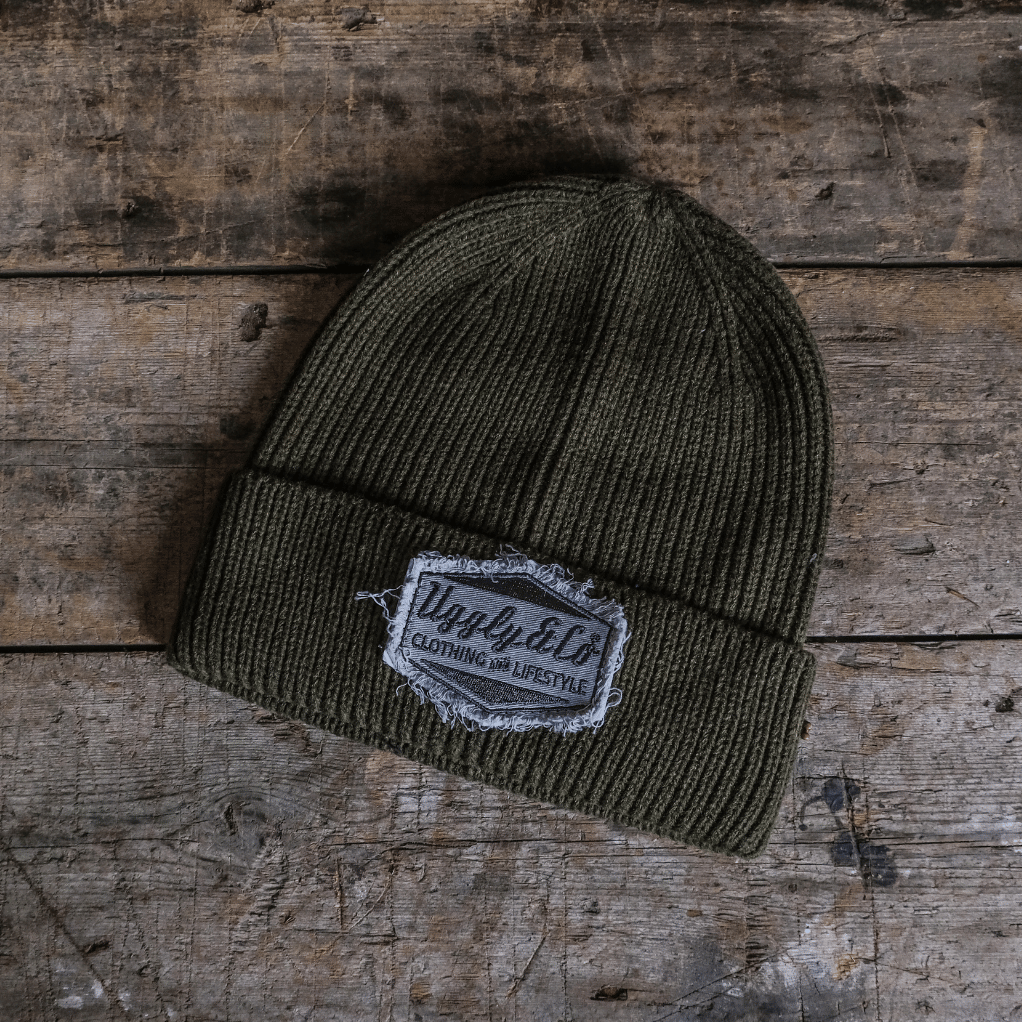Green beanie with a logo on a wooden surface