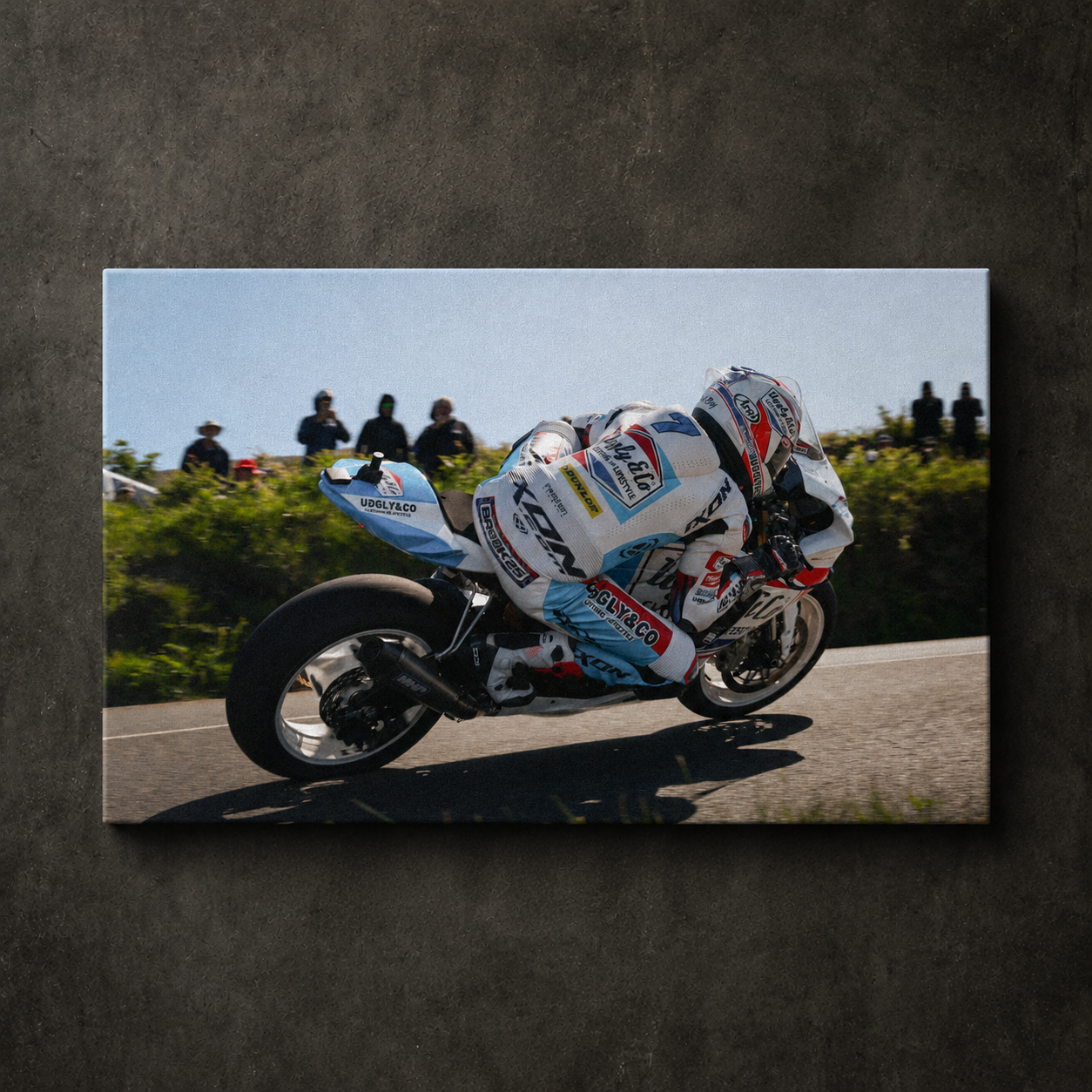 Josh Brookes riding the Uggly & Co TT bike hard through a corner with spectators in the background, shown as canvas wall art.