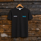 Front view of a Josh Brookes signature diamond black t-shirt with blue Uggly&Co logo on a wooden background