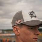 Kam Dixon wearing the grey and white Diamond Trucker Cap with motorsport-inspired styling.