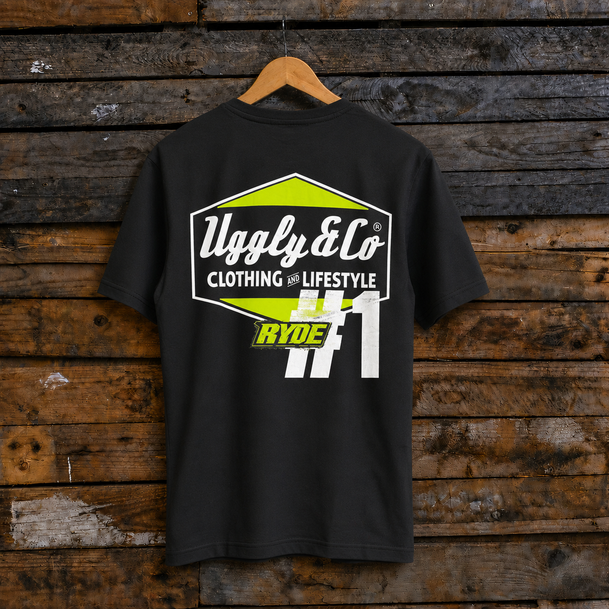 Rear view of an Uggly & Co and Kyle Ryde #1 diamond graphic black t-shirt  with white and lime green accents on a wooden background