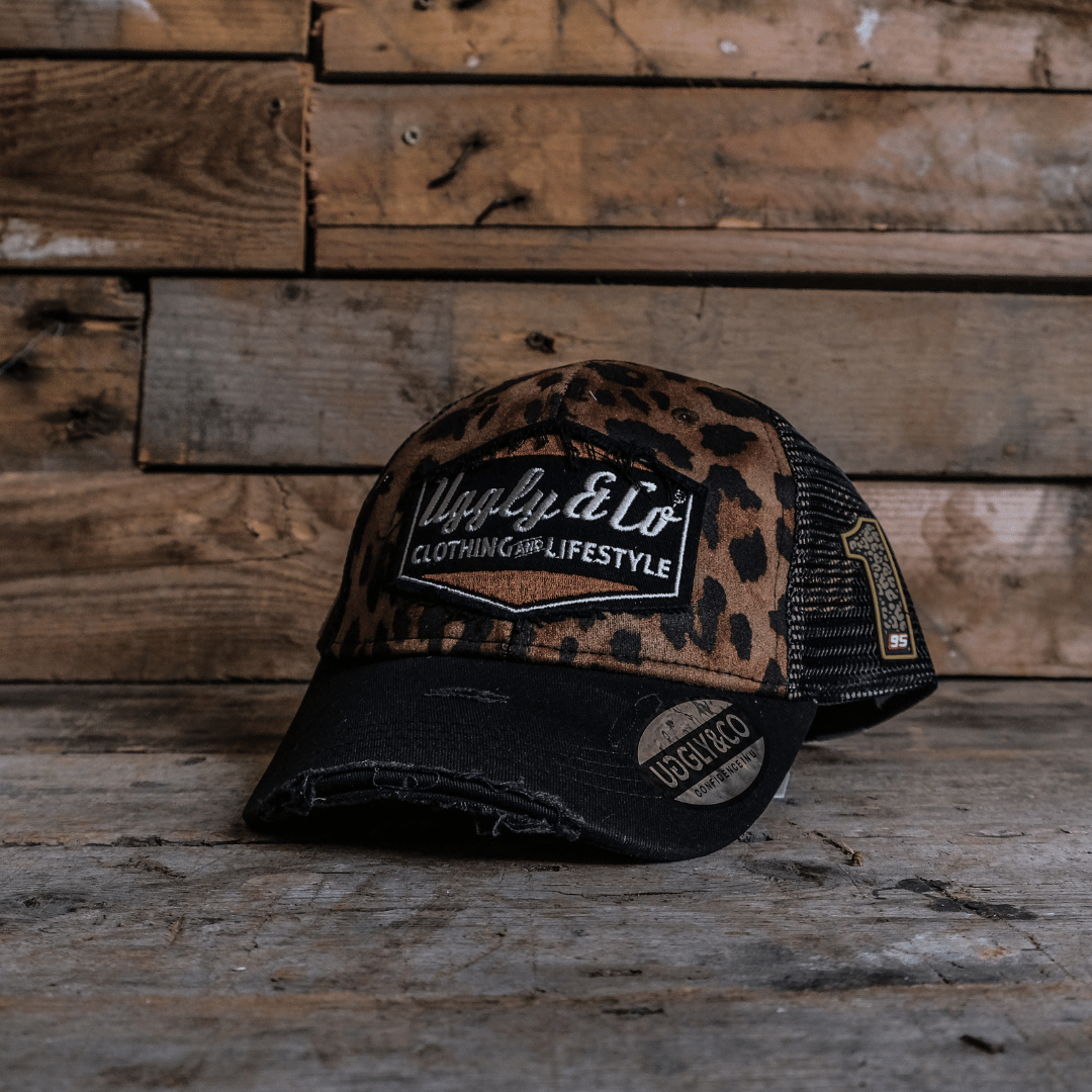 Leopard print trucker hat with Uggle&Co logo on a wooden background