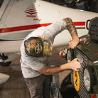 Mens Green Camo Diamond Trucker Hat styled with workwear while repairing a Land Rover.
