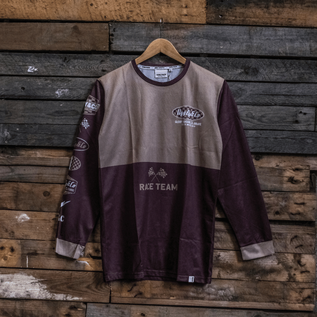 Long-sleeve MX shirt with Uggly&Co logo on a wooden background facing forwards