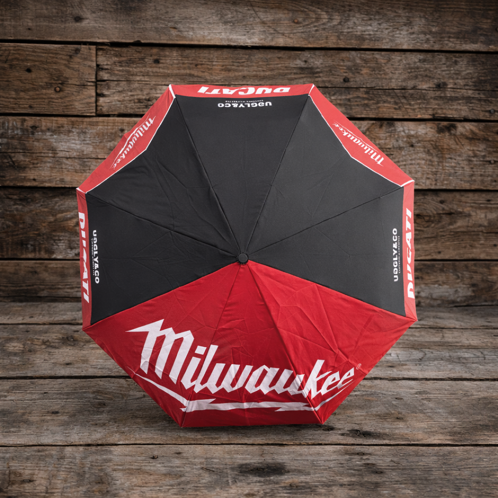 Top view of a red and black Milwaukee x Ducati umbrella with Milwaukee logo on a wooden background