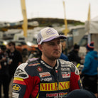 Mitch Rees wearing a white and purple trucker hat with Uggly&Co diamond logo on the front, a mesh back and Mitch Rees Racing logo on the side