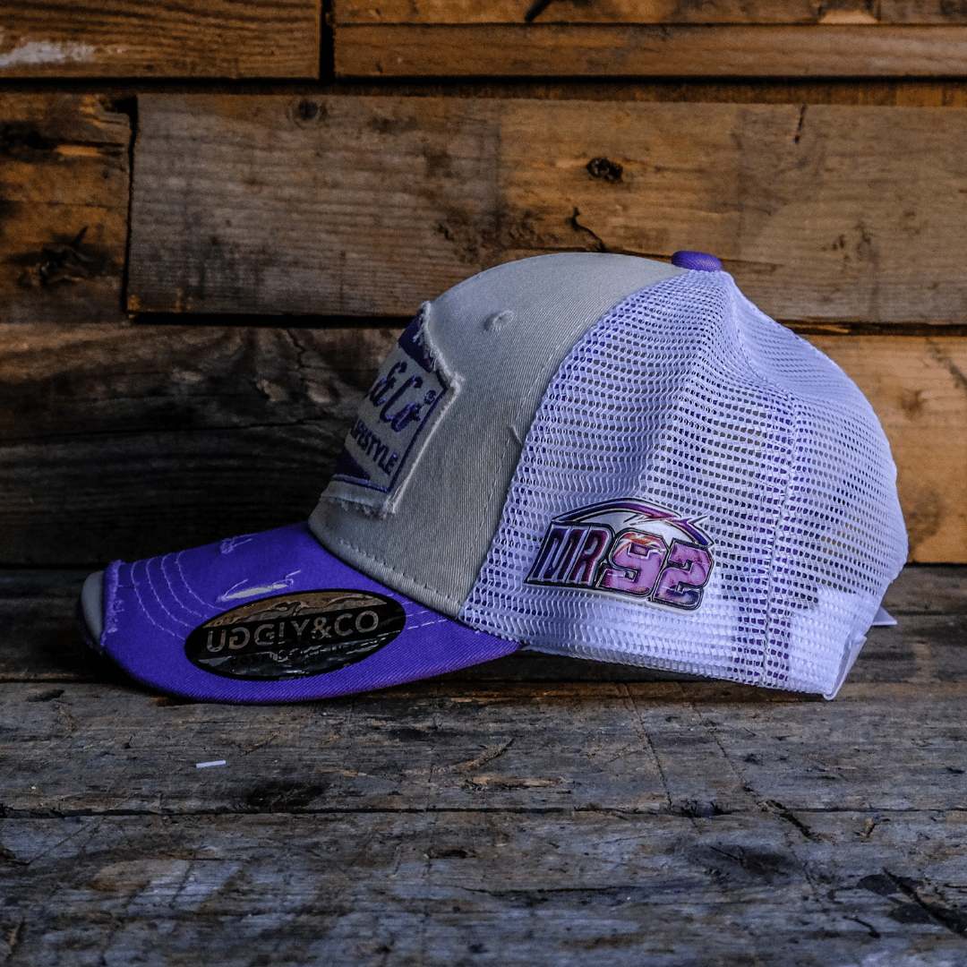 Side view of a white and purple trucker hat with Uggly&Co diamond logo on the front, a mesh back and Mitch Rees Racing logo on the side