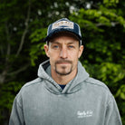 motorbike rider josh Brookes in blue diamond hat stood in front of green plants