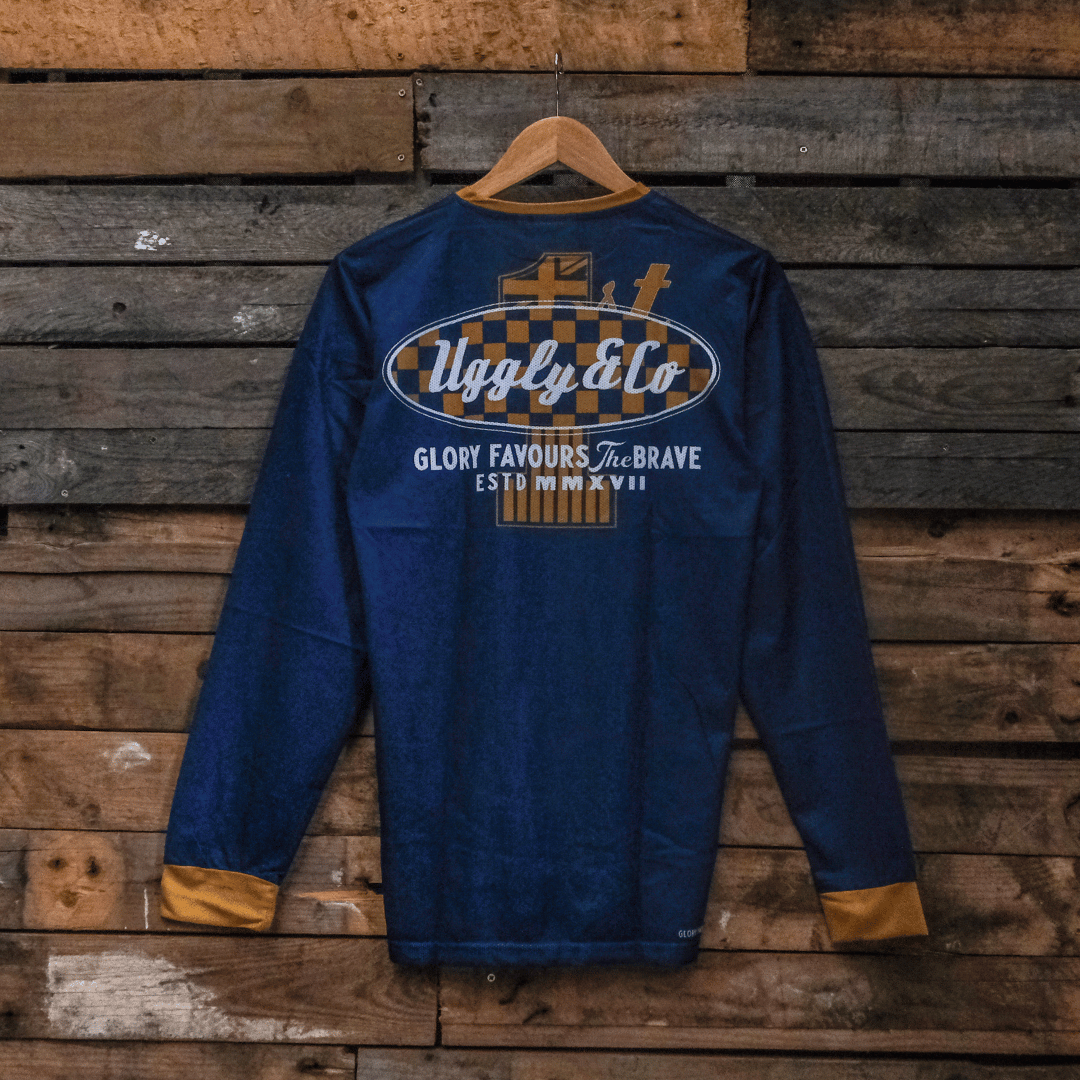 Blue MX shirt with Uggly&Co branding on a wooden background, back side