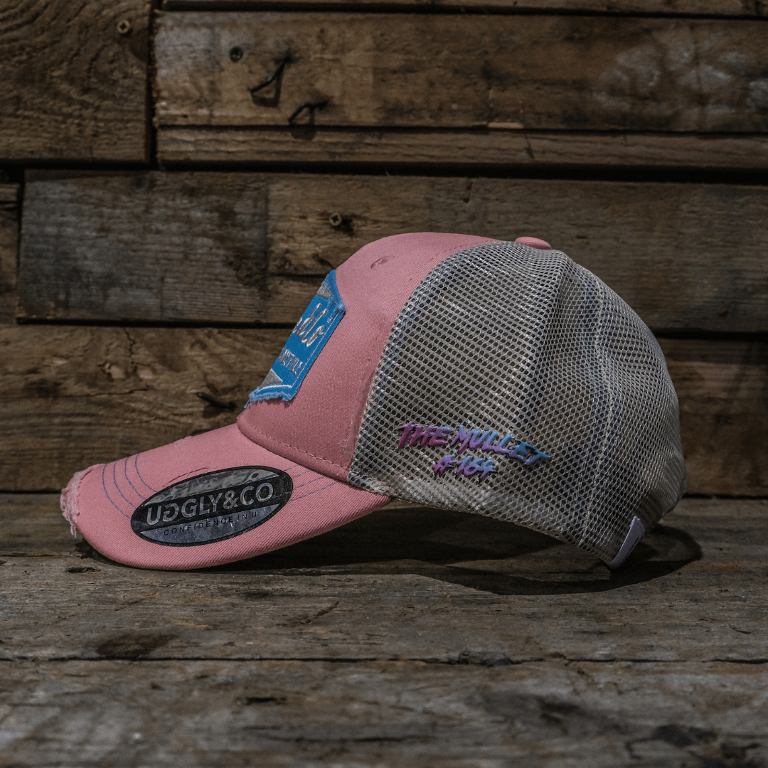 Pink and gray cap with mesh back on a wooden surface