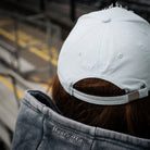 close up rear view shot of a girl wearing a blue cap at a motorsport race