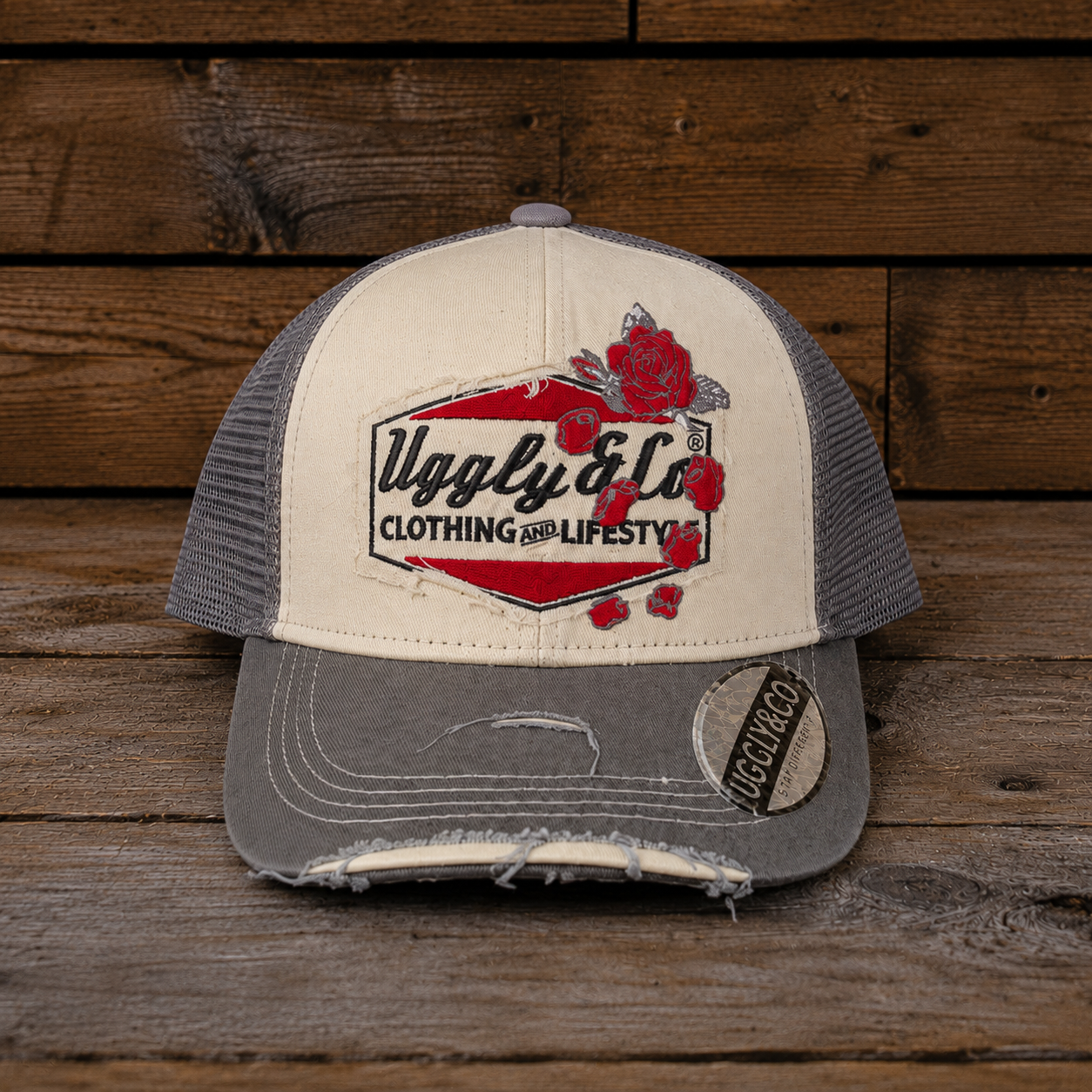 Rose Diamond Cap shown from a front angle on a rustic wooden background, featuring red rose embroidery, cream front panels, grey mesh and a distressed grey peak
