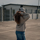 Side profile of a female model wearing the Silver & Grey Diamond Trucker Hat
