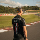 Storm Stacey wearing the Bathams Racing x AJN Steelstock Road Racing Polo from a three-quarter angle