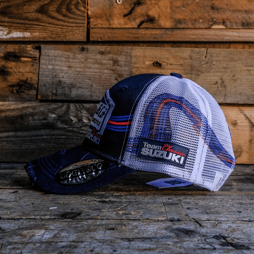 Side view of a Team Classic Suzuki trucker hat on blue, red and white, with a mesh back and an Uggly&Co diamond logo on the front