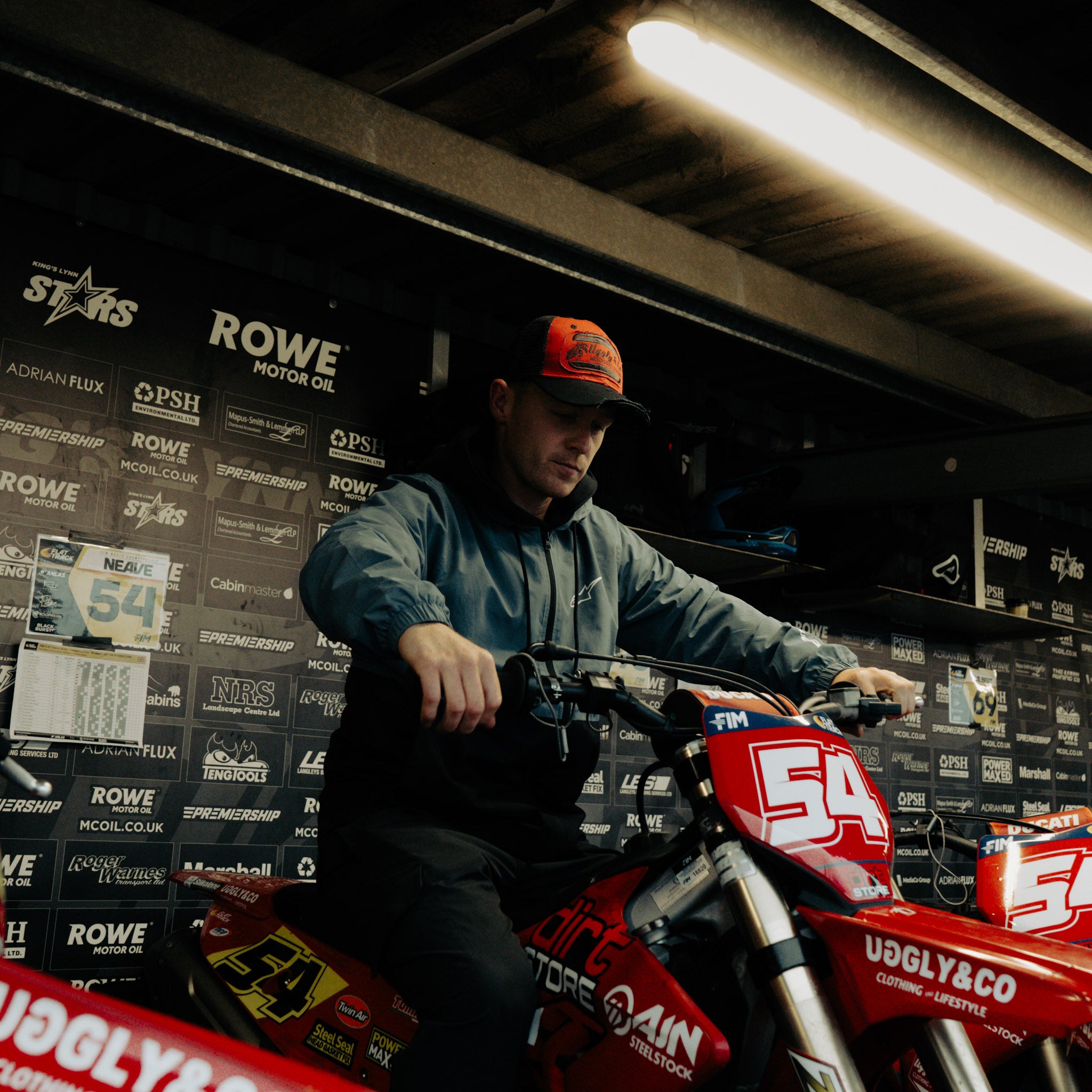 Tim Neave in the Black & Red Flat Track Trucker Hat at a flat track event, highlighting the cap’s motorsport style and mesh trucker shape.