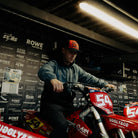Tim Neave in the Black & Red Flat Track Trucker Hat at a flat track event, highlighting the cap’s motorsport style and mesh trucker shape.