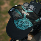 inner lining of black and turquoise trucker hat