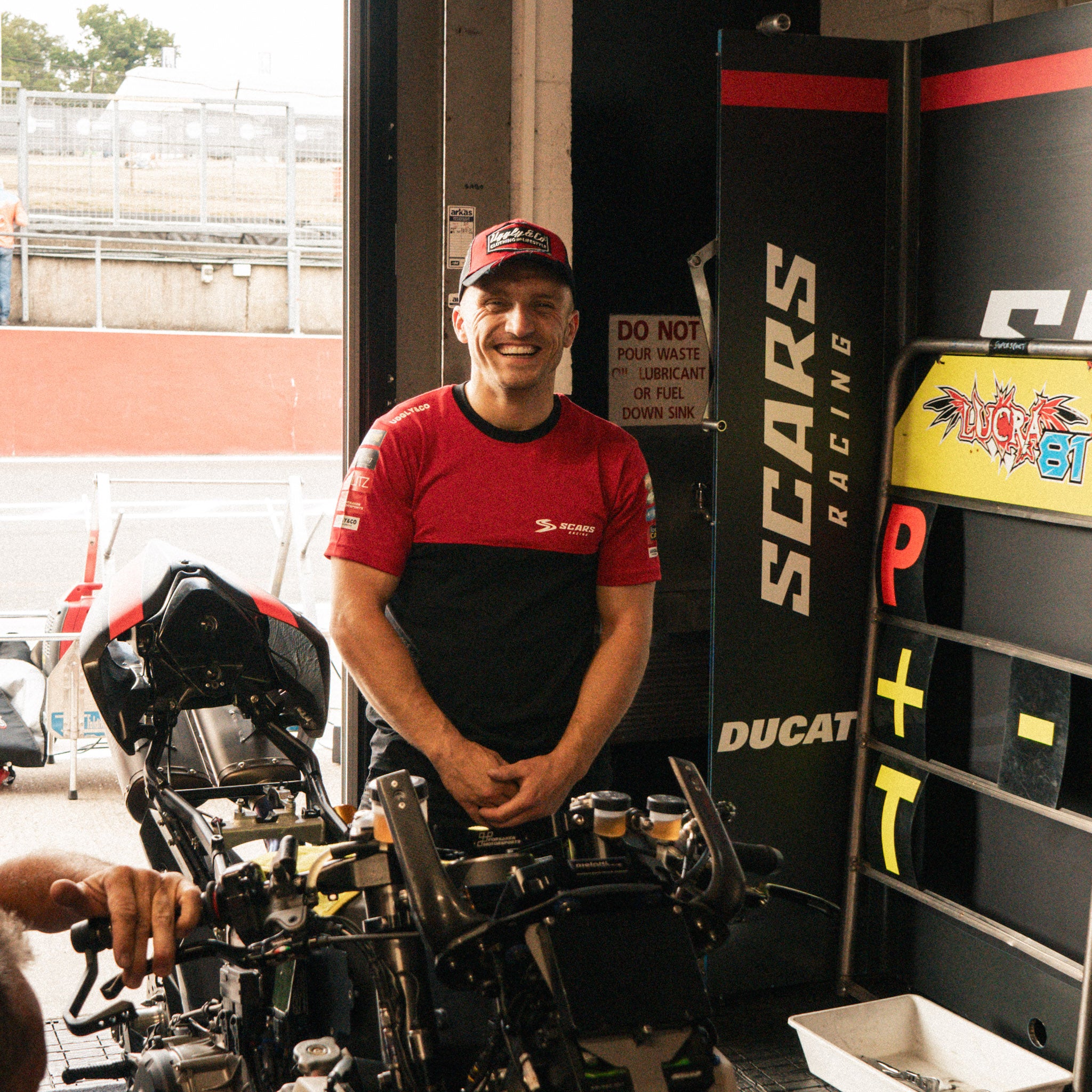 Luke Stapleford modelling Scars Racing merchandise at the racetrack