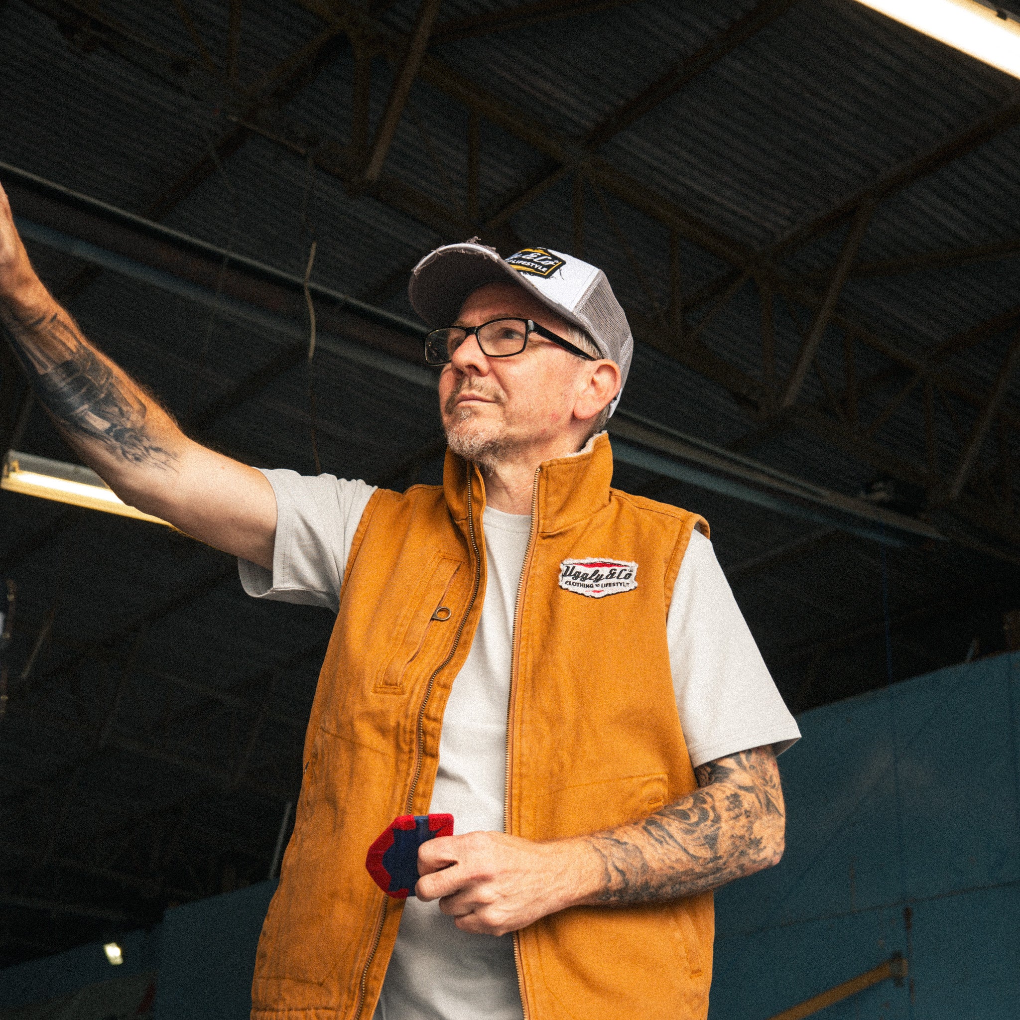Grey and white vintage trucker cap worn with casual workwear while applying graphics to a van.