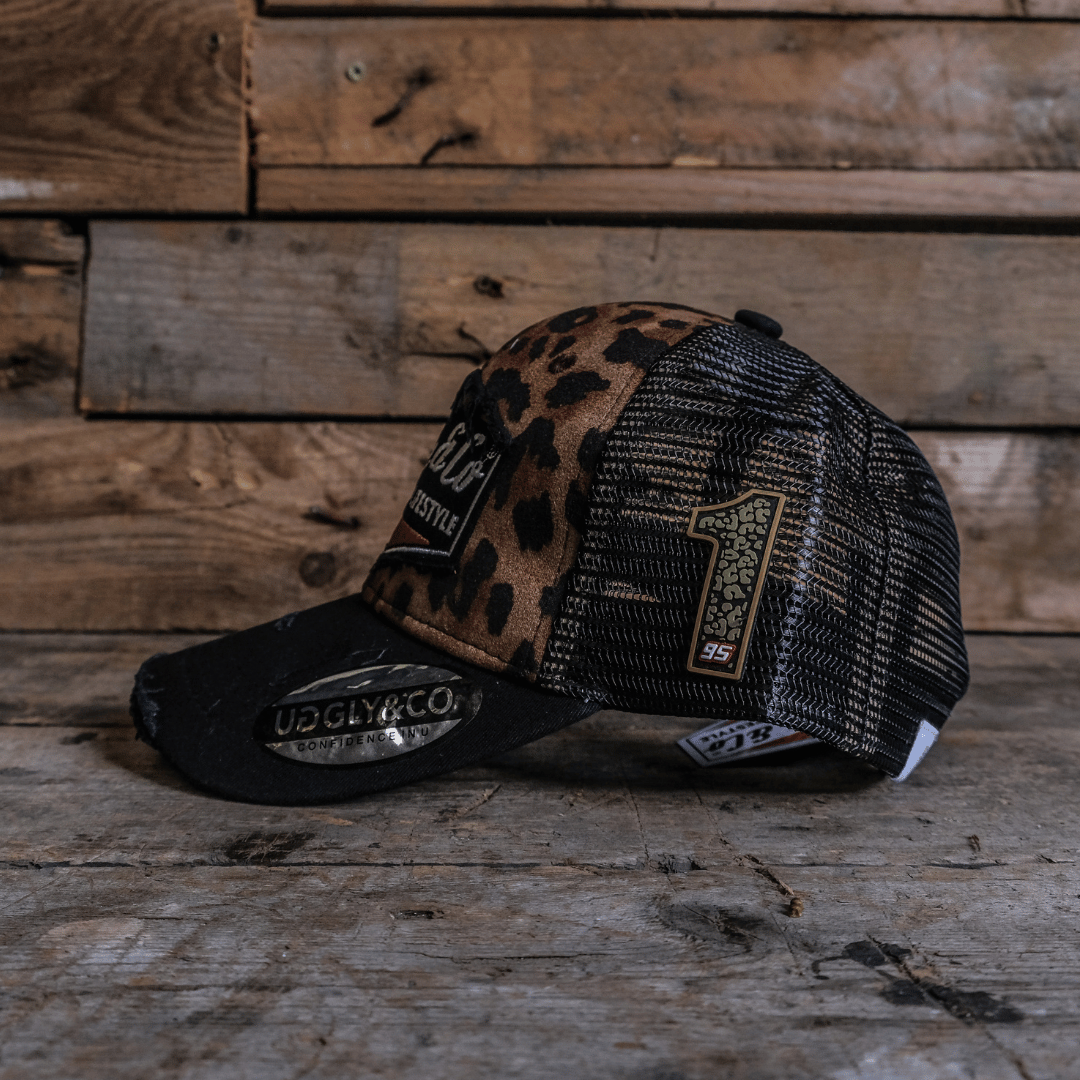 leopard print trucker hat side view on a wooden surface with a rustic background and number 1 on the side