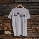 Rear view of a limited edition Valentine’s white t-shirt with spark plug heart graphic, and Uggly&Co logo on a wooden background