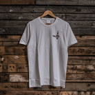 Front view of a limited edition Valentine’s white t-shirt with spark plug heart graphic, and Uggly&Co logo on a wooden background