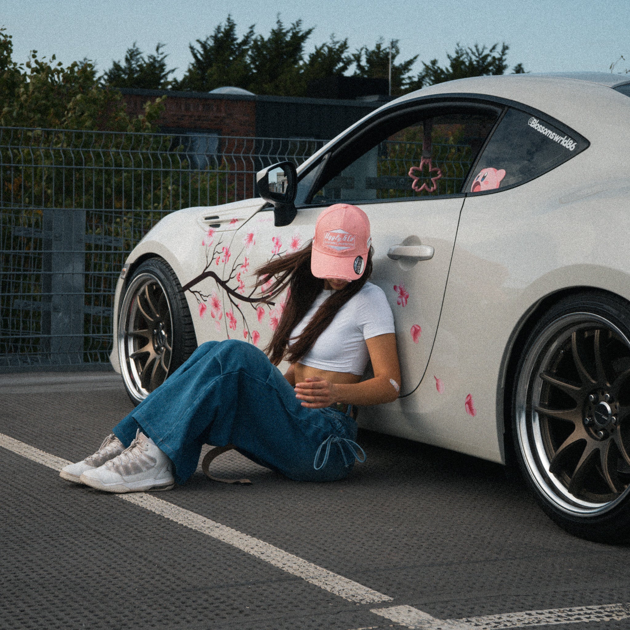 Female model wearing the Washed Pink Vintage Cap in an automotive lifestyle scene