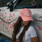 Female model styling the Washed Pink Vintage Cap with a modified car in a streetwear setting